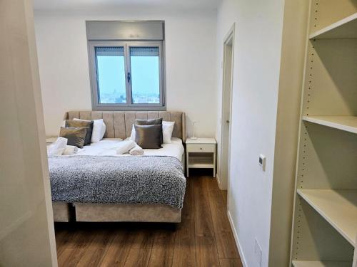 Bayit Weganוגאס的一间小卧室,配有一张带窗户的床