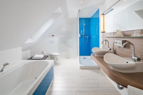 吕讷堡海利根塔尔瓦瑟穆赫酒店的浴室配有2个盥洗盆、浴缸和淋浴。