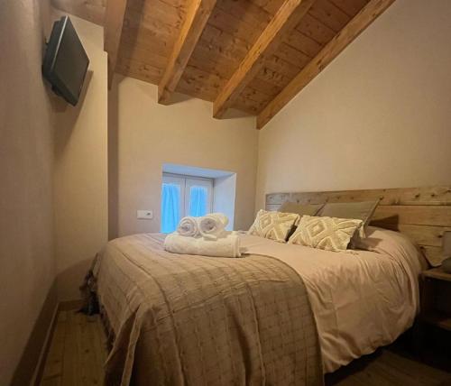 HoyocaseroCasa Rural El Encanto de Gredos的一间卧室配有一张床,上面有两条毛巾