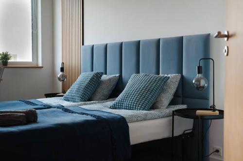 波兹南Sapphire Room Hotel Lechicka的一间卧室配有一张蓝色床头板的床