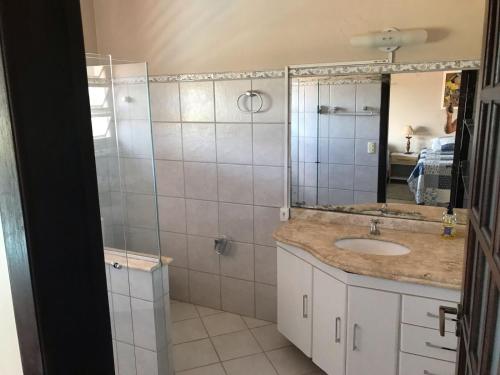 巴拉-杜加萨斯Pousada Encantos do Roncador的浴室配有盥洗盆和带镜子的淋浴