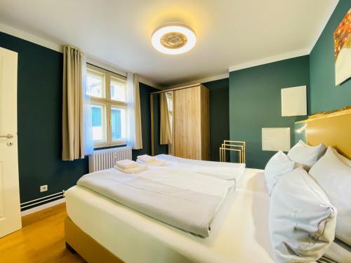 波茨坦Amaroo - Apartments Potsdam “Brandenburger Tor”的一间卧室设有两张白色的床和绿色的墙壁