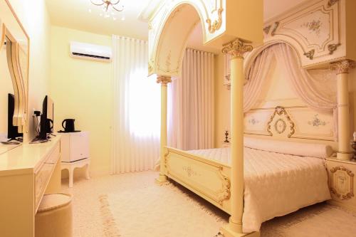 斯法克斯Gîte Feki的卧室配有白色的天蓬床和电视。