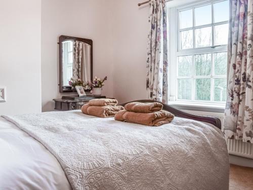Luddenden FootVintage Cottage的一间卧室配有带3个枕头的床