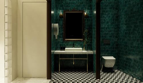 库萨达斯Ramos Hotel Kuşadası的绿色瓷砖浴室设有水槽和镜子
