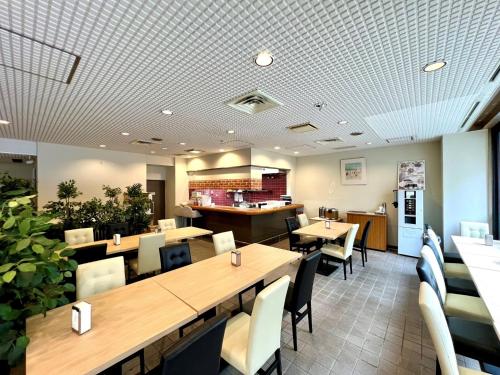 千叶Hotel Tetora Makuhari Inagekaigan - Vacation STAY 90808v的一间带桌椅和柜台的餐厅