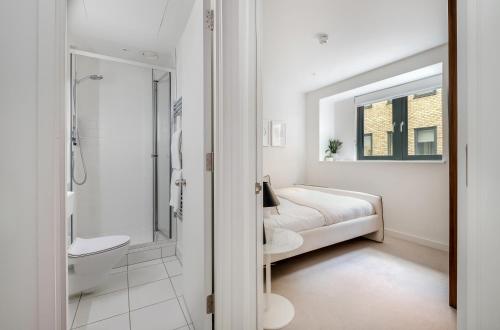 伦敦Luxury Central Mayfair Townhouse with AC 3BR 3BA的白色的浴室设有一张床和淋浴。
