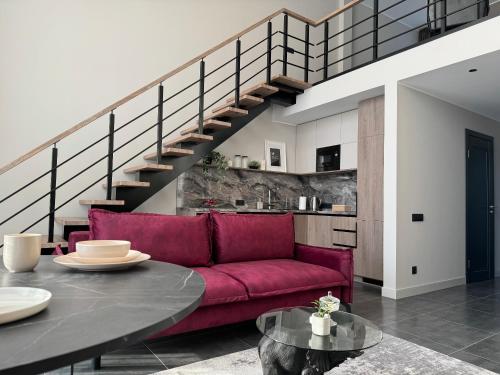 叶尔加瓦Cukura Loft的一间带红色沙发和楼梯的客厅