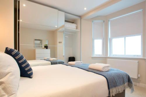 伦敦Madison Hill - Byrne Garden 2 - One bedroom home的一间卧室设有两张床和大镜子