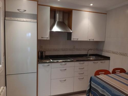 扎鲁亚斯Egona - Apartamento en el centro a 500mts de la playa Her2的厨房配有白色橱柜、水槽和炉灶。