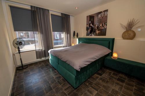 迪弗尔Appartement 1的一间卧室设有一张绿色的床和一个窗户。