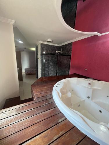 维拉可波斯Pousada Azul Ms的带浴缸的浴室和红色的墙壁
