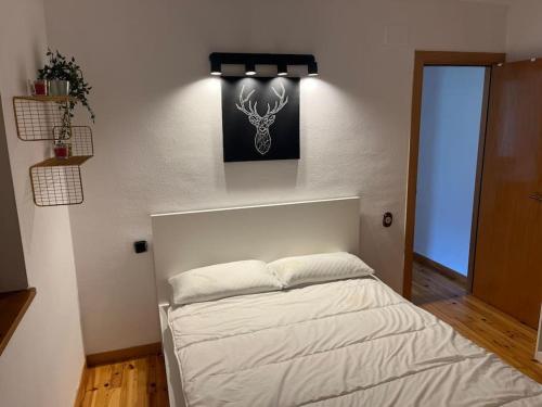 陶尔Apartamento con encanto (Taüll) DEER 1的卧室配有一张白色床,墙上挂着一幅画