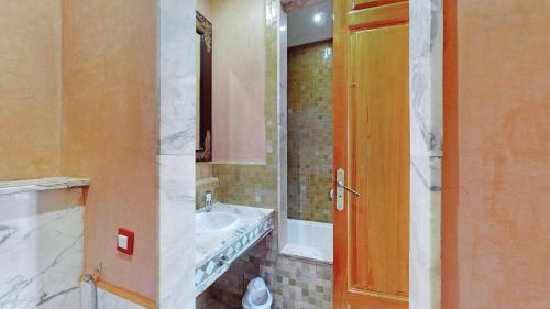 马拉喀什Appartements de charme à la palmeraie的一间带水槽和镜子的浴室