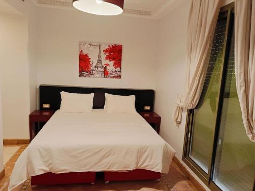 马拉喀什Appartements de charme à la palmeraie的一间卧室设有一张床和一个窗口