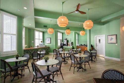 基韦斯特最南端成人独家酒店的餐厅设有桌椅和绿色的墙壁