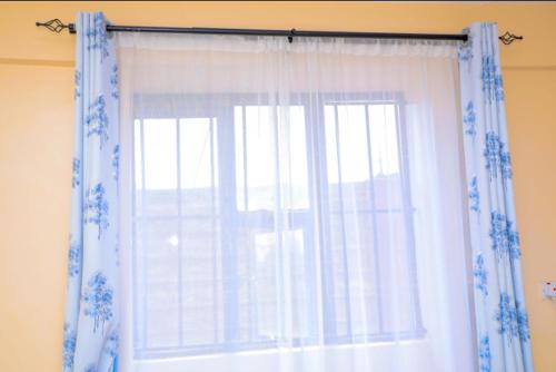 KisiiNuri Homes的窗户,有蓝色和白色的窗帘