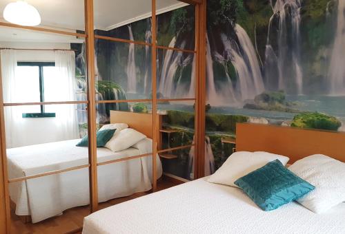 维戈Playa Samil Vigo Reformado 2016的一间卧室设有两张床和瀑布壁画