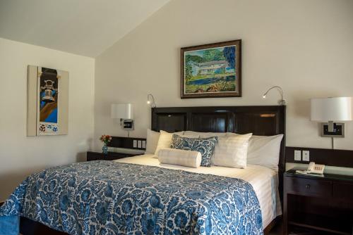 下博克特帕拉玛特酒店的一间卧室配有一张带蓝白色毯子的床