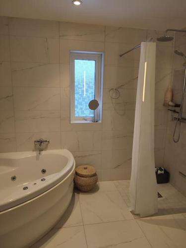 哥德堡Göteborgs Pärla nr 2的白色的浴室设有浴缸和窗户。