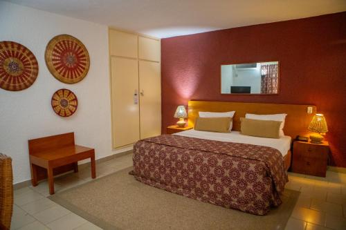 阿比让马尔利酒店的酒店客房配有一张床铺和一张桌子。