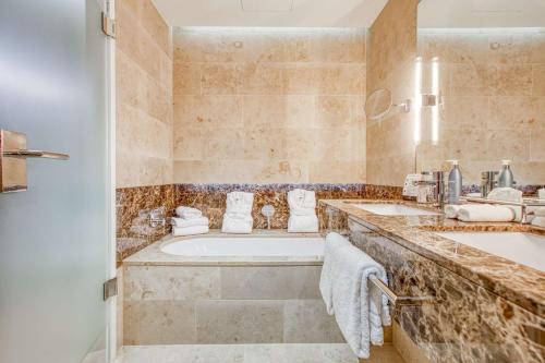 海尔布隆Parkhotel Heilbronn的浴室配有2个盥洗盆和1个浴缸。