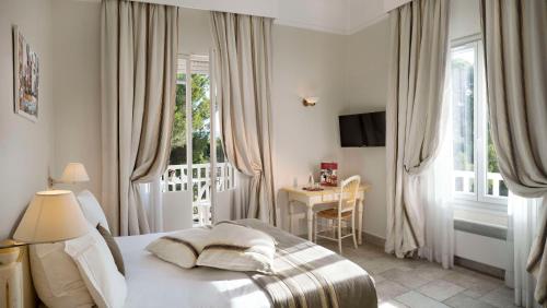 滨海圣西尔莱克斯大酒店的一间卧室配有一张床、一张桌子和一个窗户。