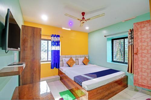 BhadrakSPOT ON Mahaveer Resort的一间卧室配有一张床和一台电视。