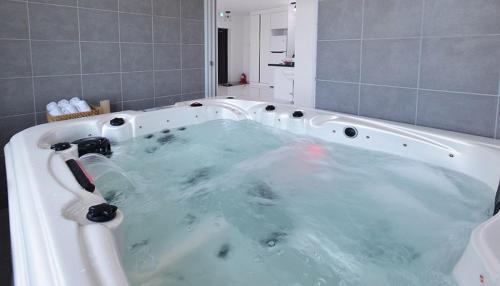 扶安Glories Pension的浴室设有装满蓝色水的浴缸。