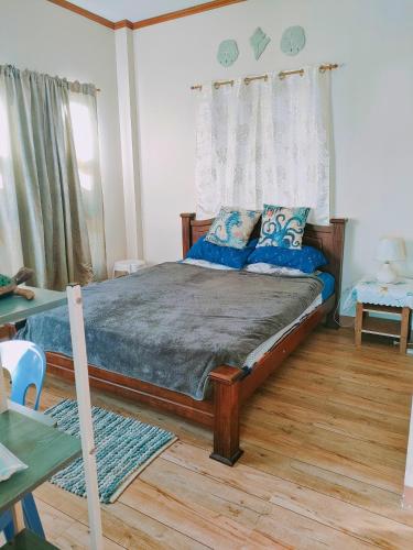 波尔多·格尼拉Puerto Galera Transient Guest Room的一间卧室配有一张带蓝色枕头的大床