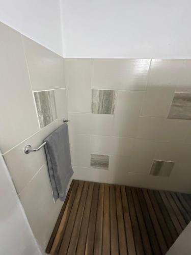 Jolly HarbourView Haven Villa的带淋浴的浴室,铺有木地板