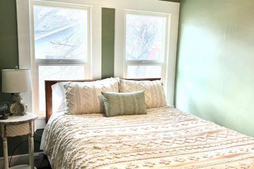 波卡特洛The Vintage Daisy的一间卧室配有带枕头的床和2个窗户。