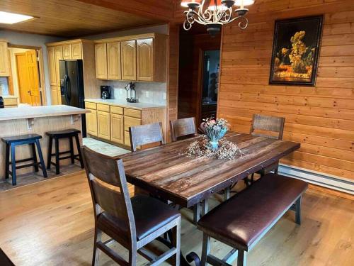ThayneCabin on the Green的厨房以及带木桌和椅子的用餐室。