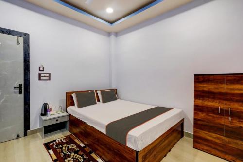 古瓦哈提Super Collection O Ashirbad Lodge的一间小卧室,配有一张床和一个梳妆台