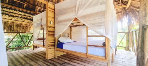 GuachacaEncanto Hostel的树屋设有一间带两张双层床的卧室