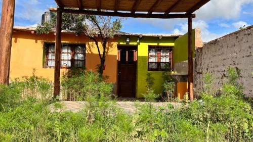 胡阿卡勒拉La Casita de la Abuela Huacalera - Quebrada de Humahuaca的黄色和绿色的房子,有门