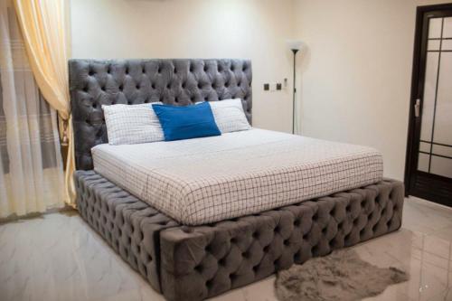 库马西Sleek Luxury Homes的卧室内的一张带垫子的大床