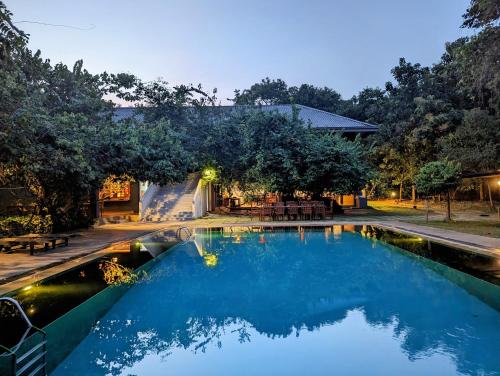 锡吉里亚Pinthaliya Resort的庭院里的一个蓝色海水游泳池