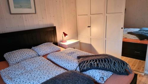 SteigenRo i Steigen的一间卧室配有两张床和床头灯。