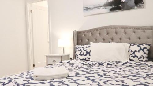 尼亚加拉瀑布Luxury 2BDR Suite Mins To Falls的一间卧室配有一张带蓝色和白色棉被的床