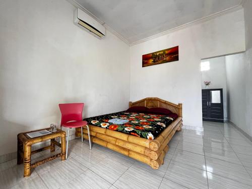 KuripanAlan's Homestay的卧室配有1张床、1张桌子和1把椅子