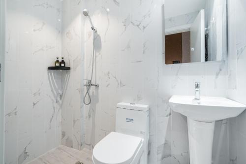 上海上海悦栖酒店虹桥机场高铁店的白色的浴室设有卫生间和水槽。