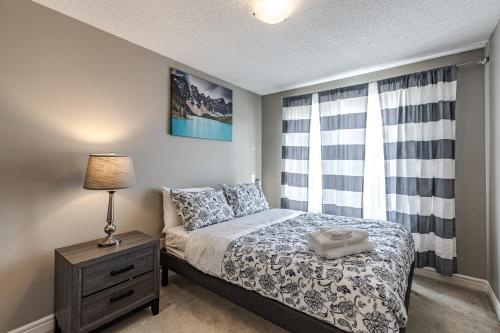 埃德蒙顿Lux-Rooms in Allard Edmonton的一间卧室配有一张床、床头柜和窗户