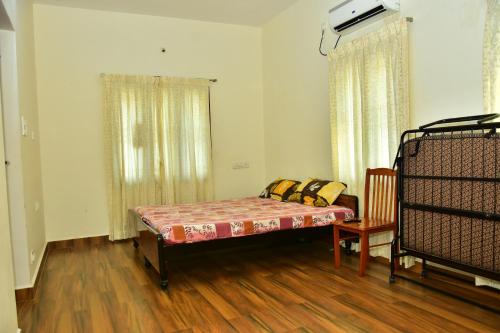 蒂鲁瓦纳马莱Narayani Resort - Serene resort with private swimming pool的一间卧室,卧室内配有一张床和一把椅子