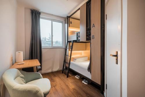 上海上海悦栖酒店虹桥机场高铁店的小房间设有双层床和椅子
