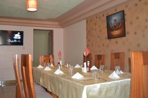 NgongJari Inn Bistro的一间会议室,配有一张长桌和白色桌布