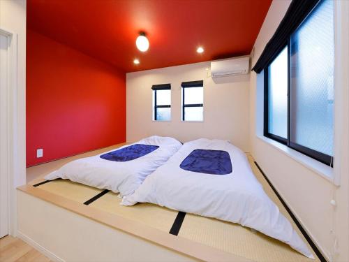 东京东京古都涩谷3公寓的红色墙壁的客房内的两张床