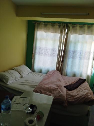 GodāvariGodawari villa guest house的一间卧室设有两张床、一张桌子和一个窗口