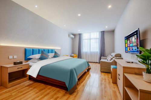 昆明曼朵酒店(昆明长水国际机场店)的一间卧室配有一张大床和一张沙发