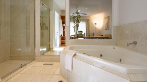 戴尔斯福特Lakeside Suite 4 - Lake View & Spa Bath的白色的浴室设有浴缸和淋浴。